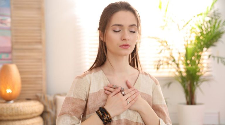 Woman connecting to Reiki energy with hands on heart center